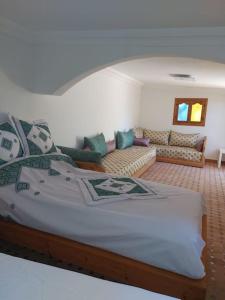 1 dormitorio con 1 cama grande y sala de estar en Villa Palmengarten Meknès bei Fes, en Meknès