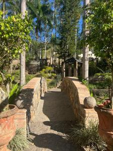 uma ponte de pedra sobre um caminho num jardim em Quinta Pichón em Tepic