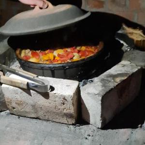 Uma pizza está a cozinhar num forno de pedra. em Drinsko Srce em Ljubovija