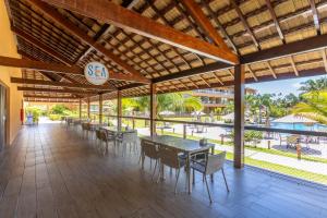 - un restaurant avec des tables et des chaises et une vue sur l'océan dans l'établissement Eco Resort Praia Dos Carneiros - Flat Praia, à Tamandaré