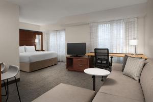 a hotel room with a bed and a tv at Residence Inn Kansas City Overland Park in Overland Park