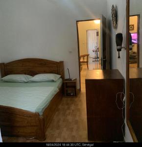 a bedroom with a bed and a dresser and a mirror at Studio Salam in Ziguinchor