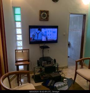 a living room with a flat screen tv on the wall at Studio Salam in Ziguinchor