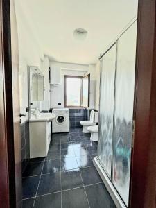 uma casa de banho com um lavatório e uma máquina de lavar roupa em Mentor’s apartment em Shkodër