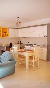 uma cozinha e sala de jantar com mesa e cadeiras em Mentor’s apartment em Shkodër