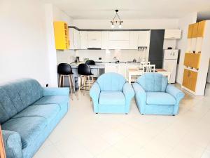 uma sala de estar com um sofá e 2 cadeiras e uma cozinha em Mentor’s apartment em Shkodër