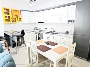 uma cozinha com uma mesa branca e uma cozinha com um frigorífico em Mentor’s apartment em Shkodër