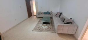 a living room with a couch and a coffee table at Résidence karim mami in Gabès