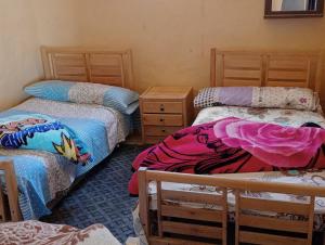 a room with two twin beds and a dresser at Karam Sands in Siwa