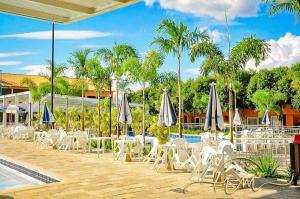 a group of chairs and umbrellas next to a pool at diRoma Fiori RM Hospedagem in Caldas Novas