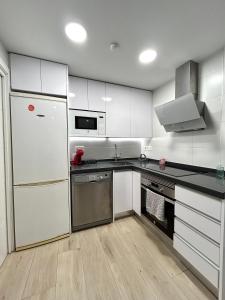 una cucina con mobili bianchi e un frigorifero bianco di Casita Playa Yolanda a Santa Pola