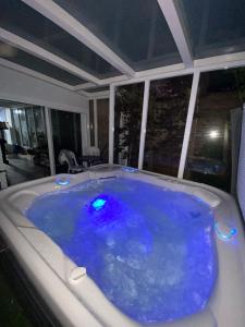eine Whirlpool-Badewanne mit blauem Wasser in einem Zimmer in der Unterkunft Michael House in Jerusalem