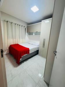 a bedroom with a bed with a red blanket on it at Casa Aconchegante com Piscina in Petrolina