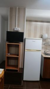 een kleine keuken met een witte koelkast en een televisie bij Coliving 87 Estudio Numero 10 in Hospitalet de Llobregat