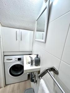 una lavanderia con lavatrice e lavandino di Casita Playa Yolanda a Santa Pola