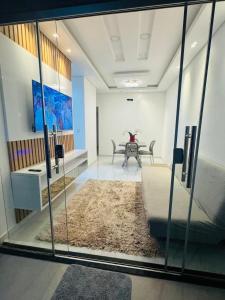 a room with a couch and a table and a glass wall at Casa Aconchegante com Piscina in Petrolina