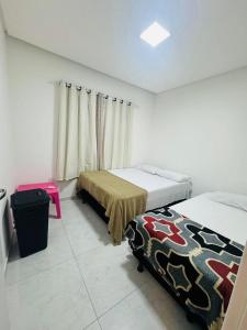 1 dormitorio con 2 camas y mesa rosa en Casa Aconchegante com Piscina en Petrolina