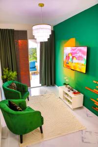 a living room with green walls and two green chairs at Agapi Mou in Gaspar Hernández