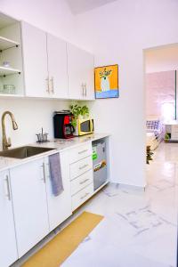 a white kitchen with a sink and a microwave at Agapi Mou in Gaspar Hernández
