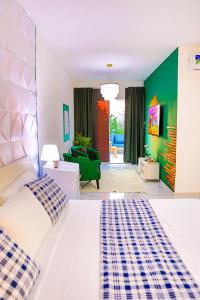 a bedroom with a white bed and a green wall at Agapi Mou in Gaspar Hernández