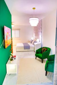 a bedroom with a bed and a green chair at Agapi Mou in Gaspar Hernández