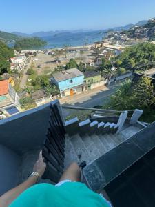 a person sitting on a balcony looking out at the ocean at Casa Bela Vista in Angra dos Reis