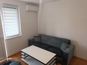 een woonkamer met een bank en een tafel bij Apartmani CENTAR in Jajce