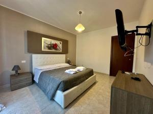 ein Schlafzimmer mit einem Bett und einem Flachbildfernseher in der Unterkunft Casa Cecilia(Villino da 2 a 8 persone) in Ladispoli
