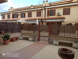 ein Gebäude mit einem Holzzaun und Topfpflanzen in der Unterkunft Casa Cecilia(Villino da 2 a 8 persone) in Ladispoli