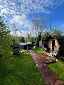 een achtertuin met een houten loopbrug en een yurt bij De Rode Zonnehoed in Scherpenzeel