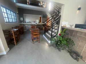 un restaurant avec un escalier, des tables et des chaises dans l'établissement Chilli Brasil Suite, à Ubatuba