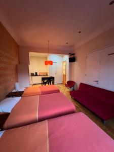 a large room with two beds and a couch at APARTHOTEL POVIDENCIA Santiago in Santiago