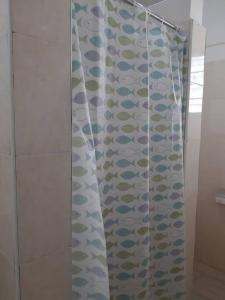 a shower curtain with fishes on it in a bathroom at The Alpha residence in Tema