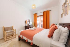 - une chambre avec un lit, une chaise et une fenêtre dans l'établissement Appartement Chic Gueliz Plaza avec Vue, à Marrakech
