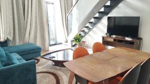 een woonkamer met een tafel en een televisie bij Golden Place Properties At The Embassy Gardens in Accra