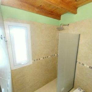a bathroom with a shower with a window and a toilet at Chalet Liwen in San Martín de los Andes