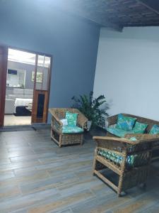 a living room with wicker chairs and a blue wall at Ótimo lugar e conforto in Piranhas