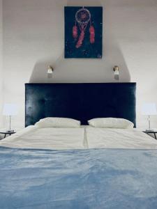 un grand lit avec une tête de lit bleue et deux lampes dans l'établissement H&A Suite Newly City Center 2 Bed & convenient, à Budapest