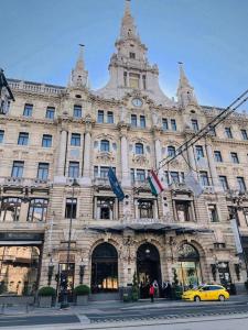 une voiture jaune garée devant un grand bâtiment dans l'établissement H&A Suite Newly City Center 2 Bed & convenient, à Budapest