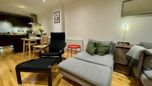 布羅姆利的住宿－Entire Apartment in London，带沙发和椅子的客厅以及厨房。