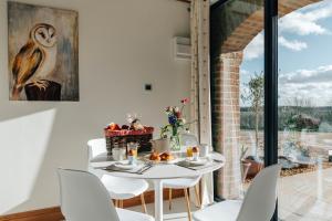 a dining room with a white table and chairs at The Linhay in Peterborough