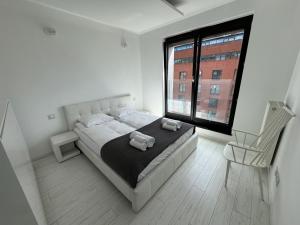 ein Schlafzimmer mit einem Bett, einem Stuhl und einem Fenster in der Unterkunft Black&White Angel Apartment in Krakau