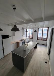 a large white kitchen with a large island in it at Chambres spacieuses hyper centre in Saint-Étienne