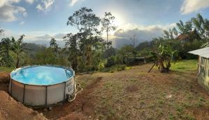 una bañera de hidromasaje en un campo junto a una casa en Rancho Luna, en Cartago