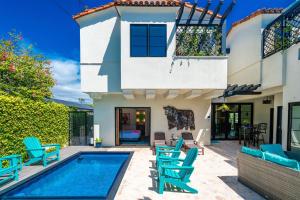 a villa with a swimming pool and blue chairs at Spanish Villa with View Pool and Spa in San Diego