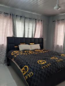 a bedroom with a bed with a black and gold bedspread at The Alpha* residence in Tema