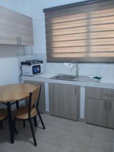 a kitchen with a table and a sink and a stove at The Alpha* residence in Tema