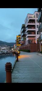 a dock with buildings next to a body of water at Nydelige Damsgårdsveien, 3-roms moderne leilighet! in Bergen