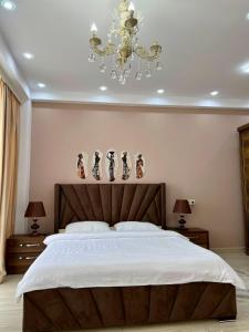 - une chambre avec un grand lit et un lustre dans l'établissement White bridge apartment, à Koutaïssi