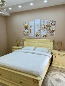 - une chambre avec un grand lit orné de 4 peintures murales dans l'établissement White bridge apartment, à Koutaïssi